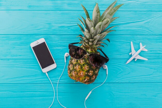 Composition d&#39;été avec ananas, lunettes de soleil et téléphone portable