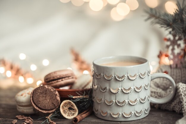 Composition festive avec tasse sur une surface en bois avec des lumières