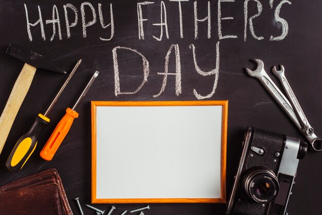 Composition de fête des pères sur tableau noir avec des outils et cadre