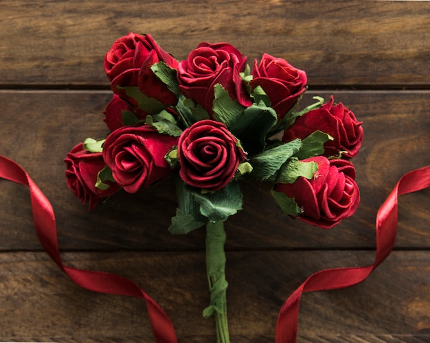 Photo gratuite composition de fleurs rouges près du ruban