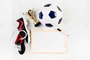 Photo gratuite composition de football avec tableau blanc et chaussures