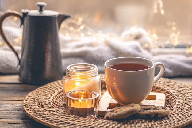 Photo gratuite composition maison confortable avec une tasse de bougies à thé et une théière