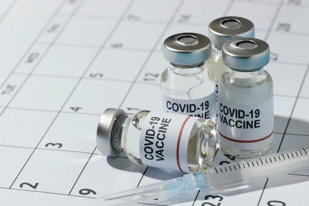 Photo gratuite composition minimale des bouteilles de vaccin sur le calendrier