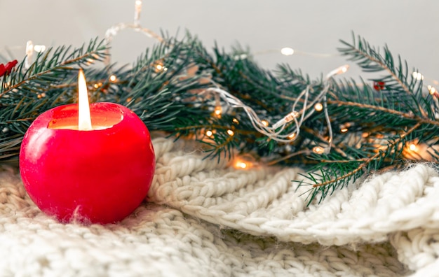 Photo gratuite composition de noël avec une bougie un élément tricoté avec des branches de sapin