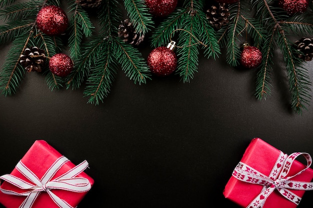 Composition de Noël de branches de sapin avec des coffrets cadeaux roses