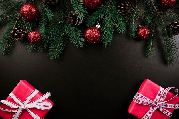 Composition de Noël de branches de sapin avec des coffrets cadeaux roses