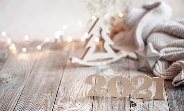 Composition de nouvel an festif avec numéro de nouvel an en bois sur un arrière-plan flou léger avec décoration de Noël.