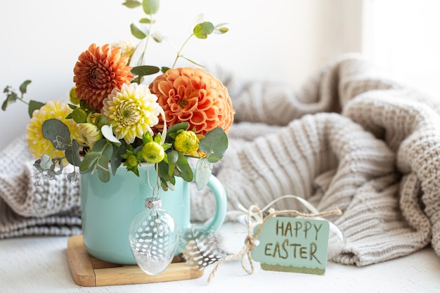 Composition de pâques avec un bouquet de fleurs et un élément tricoté