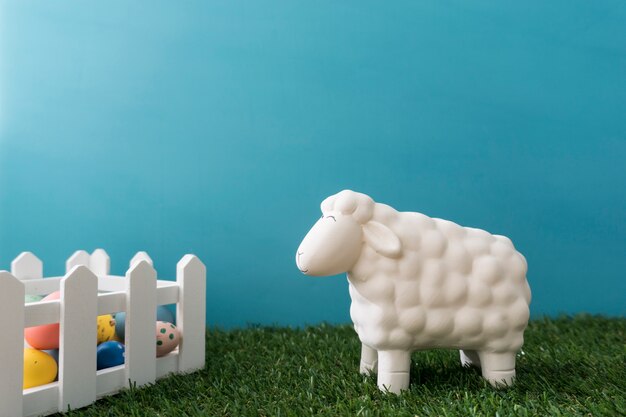 Composition de Pâques fantastique avec des moutons à côté de la clôture en bois