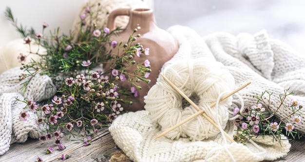 Composition avec une pelote de fil à tricoter et des fleurs