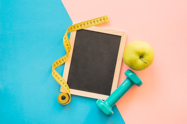 Photo gratuite composition de perte de poids avec la pomme et l'haltère