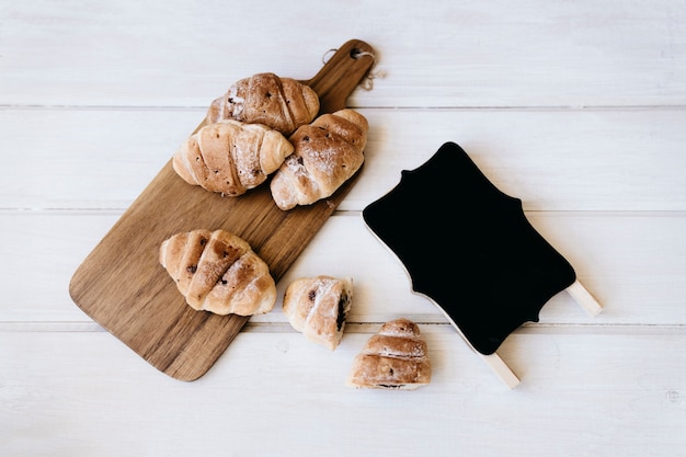 Composition de petit-déjeuner avec badge et croissants