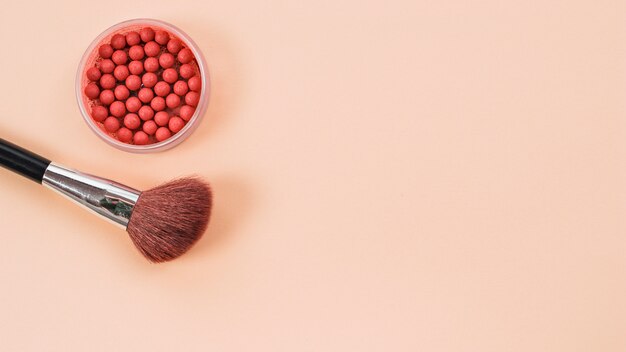 Composition de pinceau de maquillage et rouge sur fond clair