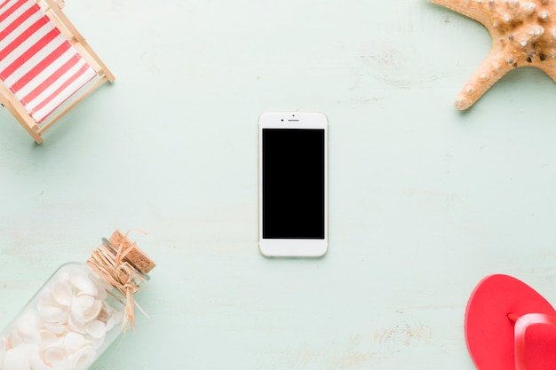 Composition de la plage avec smartphone sur fond clair