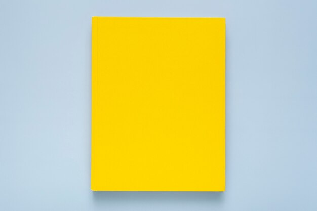 Composition plate avec cahier jaune sur fond bleu