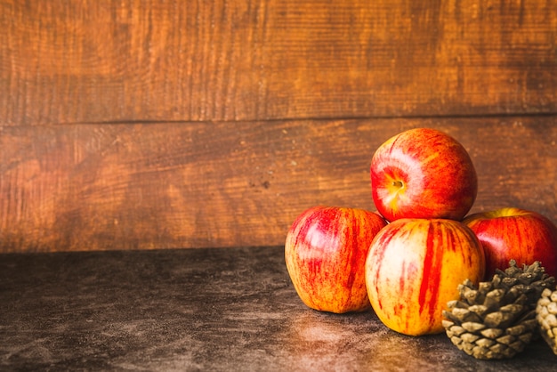 Composition avec pommes rouges et pommes de pin