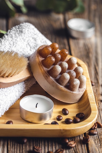 Photo gratuite composition de spa avec savon de massage au café sur une surface en bois