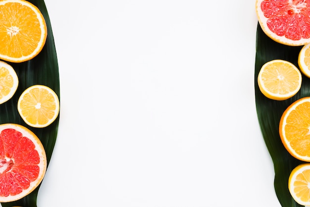 Composition de tranches de fruits exotiques sur une feuille de bananier sur fond blanc