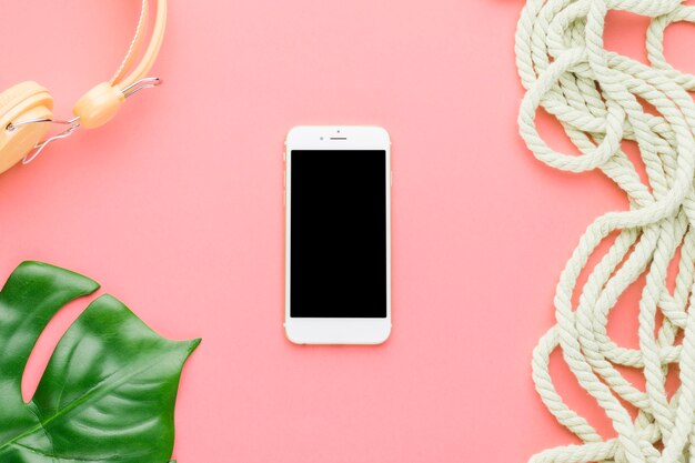 Composition de vacances à la plage avec un téléphone portable sur un fond coloré