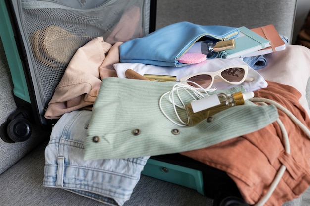 Photo gratuite composition de vêtements et accessoires dans une valise