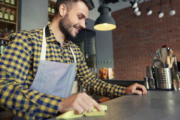 Comptoir de bar de nettoyage de serveur avant le travail