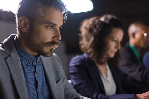 Concentré de bel homme d'affaires en regardant un ordinateur portable