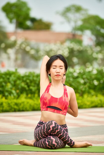 Concentré femme faisant du yoga dans le parc