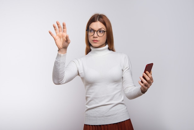 Concentré de jeune femme à l'aide de smartphone