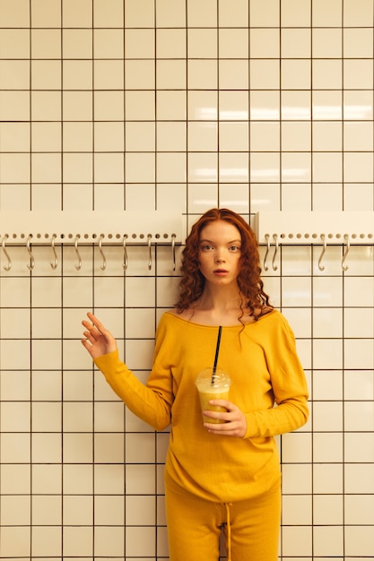 Concentré jeune femme rousse bouclée debout dans un café