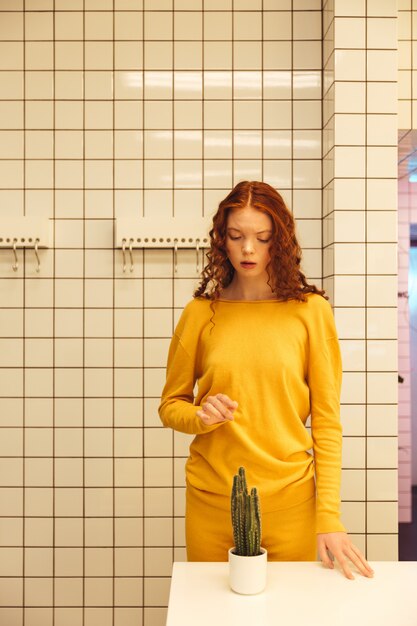 Concentré jeune femme rousse bouclée debout dans un café