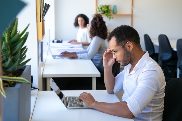 Concentré de jeune homme regardant un ordinateur portable