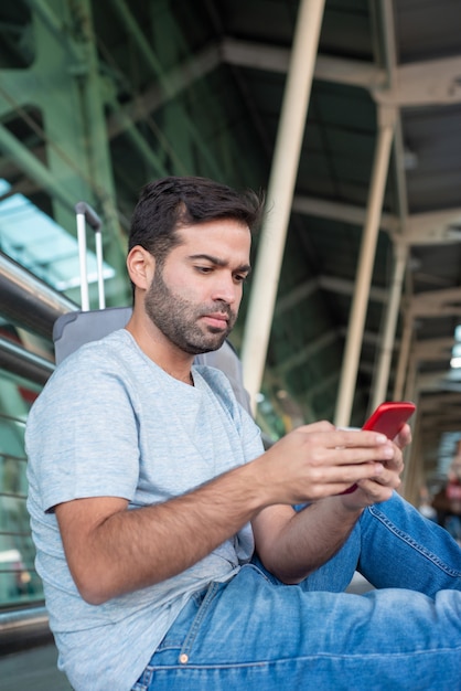 Concentré de jeune voyageur regardant smartphone