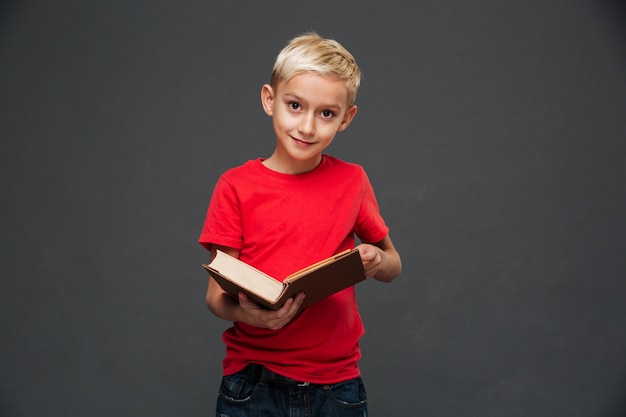 Concentré de petit garçon enfant tenant le livre.