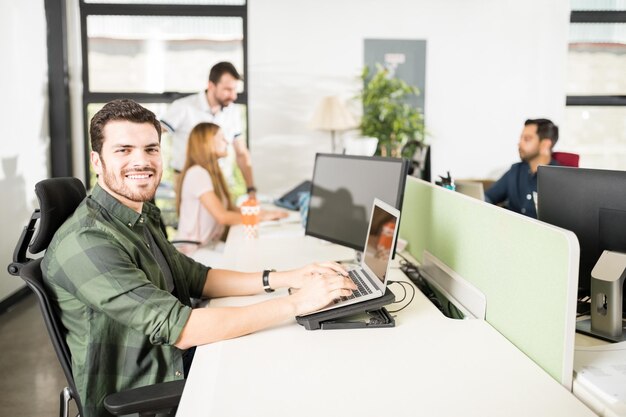 Concentrez-vous sur un homme d'affaires qui établit un contact visuel pendant qu'il travaille à sa table au bureau