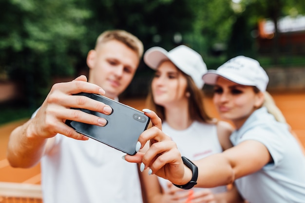 Concentrez-vous sur les joueurs de teniss qui font un selfie au téléphone.