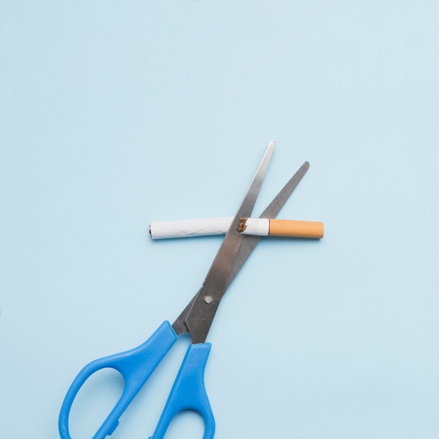 Concept anti-tabac avec cigarette et ciseaux sur fond coloré