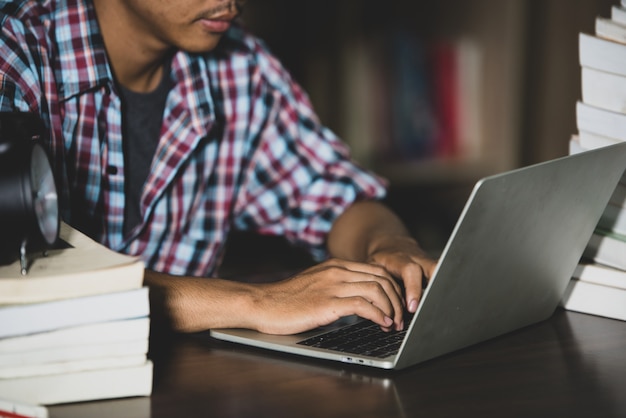 Photo gratuite concept d'apprentissage: close up student utilisant un ordinateur portable dans une bibliothèque