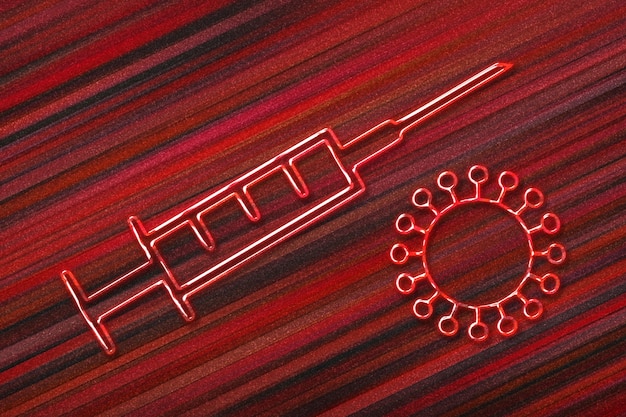 Concept d'arrêt du coronavirus, symbole de seringue médicale, vaccination, fond rouge