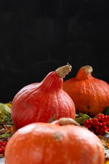 Concept D'automne Avec Une Citrouille Sur Fond Sombre Avec Des Feuilles D'automne Célébrant Halloween Et Photo Premium