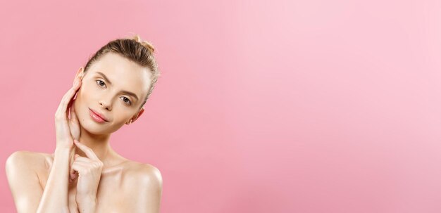 Concept de beauté belle femme avec une peau fraîche et propre gros plan sur le studio rose soins de la peau visage cosmeto