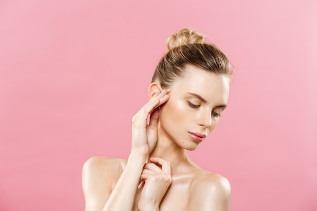 Concept de beauté - Belle femme avec une peau propre et fraîche sur le studio rose. Visage de soins de la peau. Cosmétologie.