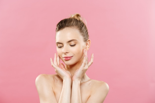 Concept de beauté - Belle femme avec une peau propre et fraîche sur le studio rose. Visage de soins de la peau. Cosmétologie.