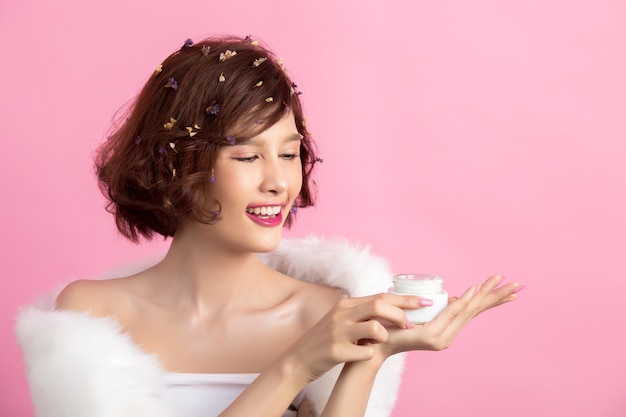 Photo gratuite concept de beauté. femme tient une crème hydratante dans sa main