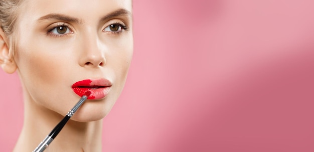 Concept de beauté happy fashion woman with long hair et lèvres rouges posant sur rose studio ba
