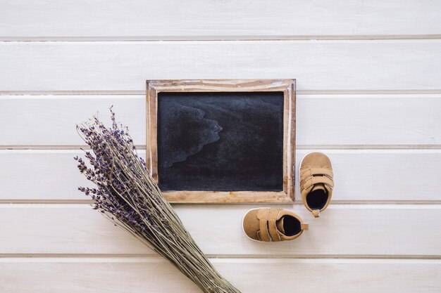 Concept de bébé avec ardoise et branches sur une surface en bois