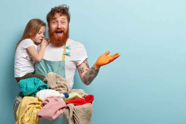 Concept de blanchisserie et de ménage. Homme rousse ravi avec une barbe épaisse