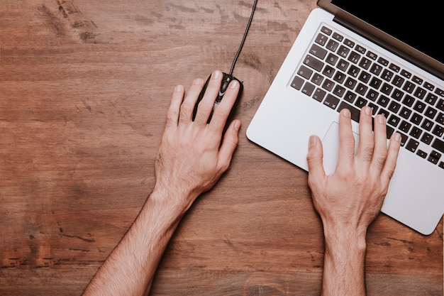 Concept de bureau de travail avec les mains travaillant sur un ordinateur portable