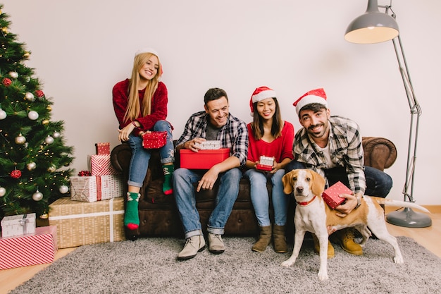 Concept de cadeau de Noël avec des amis sur le canapé et le chien