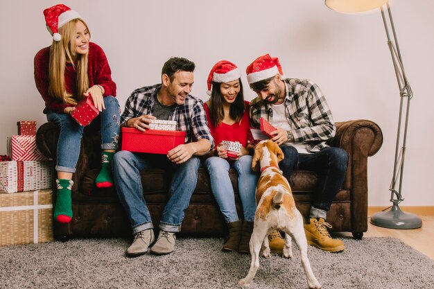 Concept de cadeau de Noël avec un groupe de quatre amis et un chien