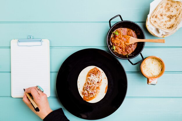 Concept de cuisine mexicaine avec les mains préparant le burrito